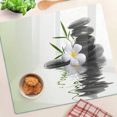 Tabla de cortar de cristal Flores y piedras en el agua