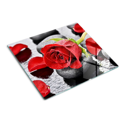 Tabla para cortar Rosa sobre piedras con gotas de agua