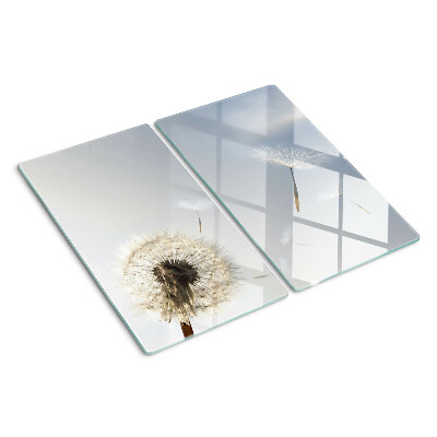 Tabla de cortar de cristal Dientes de león en el fondo de la ventana.