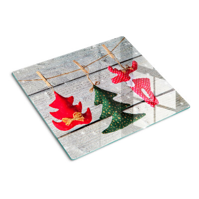 Tabla de cortar de cristal Adornos navideños sobre un fondo de madera.
