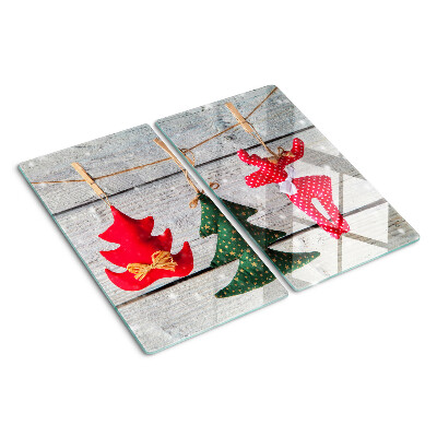 Tabla de cortar de cristal Adornos navideños sobre un fondo de madera.