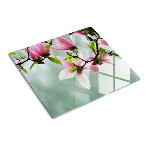 Tabla para cortar Flores de magnolia sobre un fondo verde.