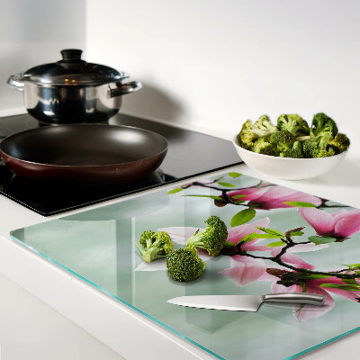Tabla para cortar Flores de magnolia sobre un fondo verde.