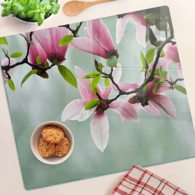 Tabla para cortar Flores de magnolia sobre un fondo verde.