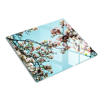Tabla para cortar Flores de magnolia sobre fondo azul.