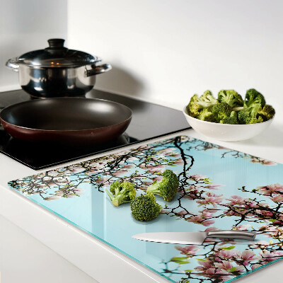 Tabla para cortar Flores de magnolia sobre fondo azul.