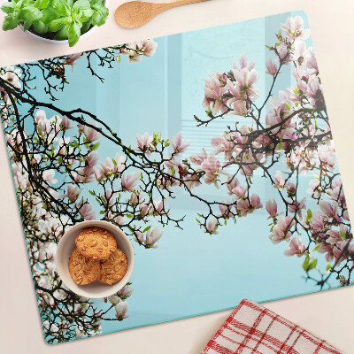 Tabla para cortar Flores de magnolia sobre fondo azul.