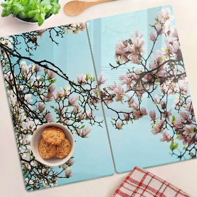 Tabla para cortar Flores de magnolia sobre fondo azul.