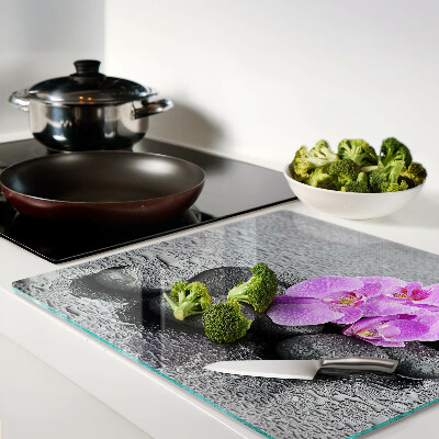 Tabla de cortar de cristal Flores y piedras contra el agua.