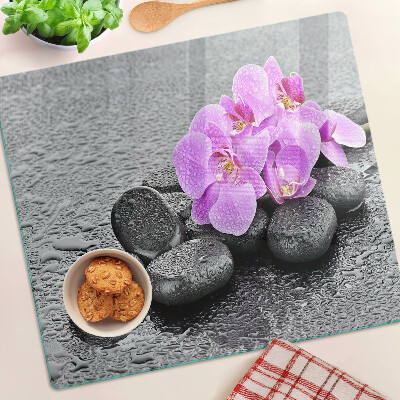 Tabla de cortar de cristal Flores y piedras contra el agua.