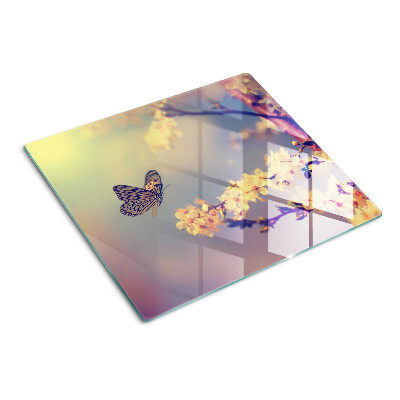 Tabla de cortar de cristal Motivo de mariposa sobre un fondo de flores.