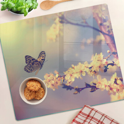 Tabla de cortar de cristal Motivo de mariposa sobre un fondo de flores.