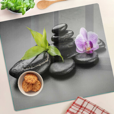 Tabla para cortar Piedras y orquídea al fondo.