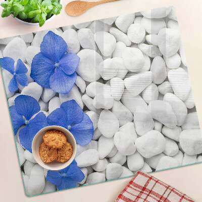 Tabla de cortar de cristal Flores azules sobre piedras blancas