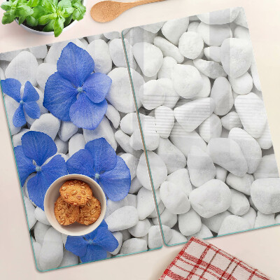 Tabla de cortar de cristal Flores azules sobre piedras blancas