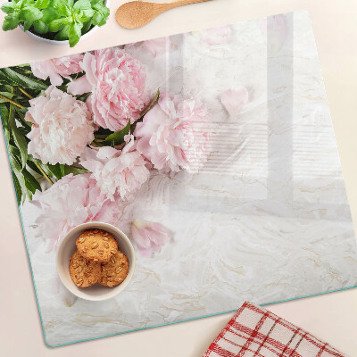 Tabla para cortar Flores de peonía sobre un fondo de mármol.