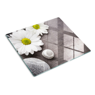 Tabla de cortar de cristal Flores y piedras en el fondo.