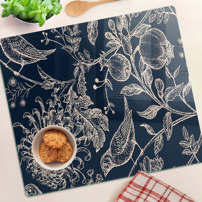 Tabla de cortar de cristal Flores y pájaros sobre un fondo oscuro.