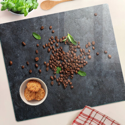 Tabla de cortar de cristal Granos de café sobre un fondo de piedra