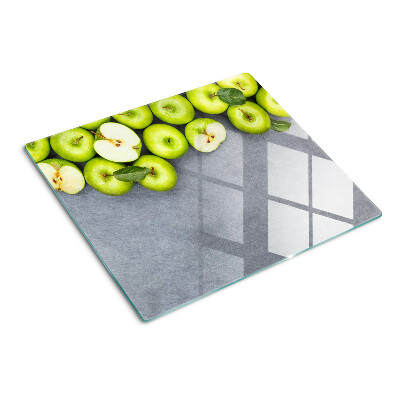 Tabla de cortar de cristal Manzanas verdes sobre una superficie gris