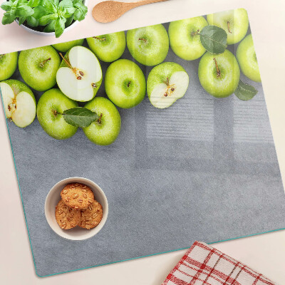 Tabla de cortar de cristal Manzanas verdes sobre una superficie gris
