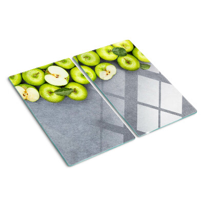 Tabla de cortar de cristal Manzanas verdes sobre una superficie gris