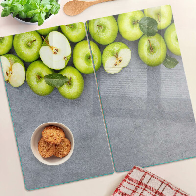 Tabla de cortar de cristal Manzanas verdes sobre una superficie gris