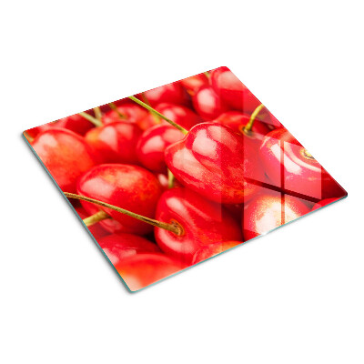 Tabla para cortar Cerezas sobre un fondo rojo
