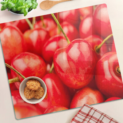 Tabla para cortar Cerezas sobre un fondo rojo