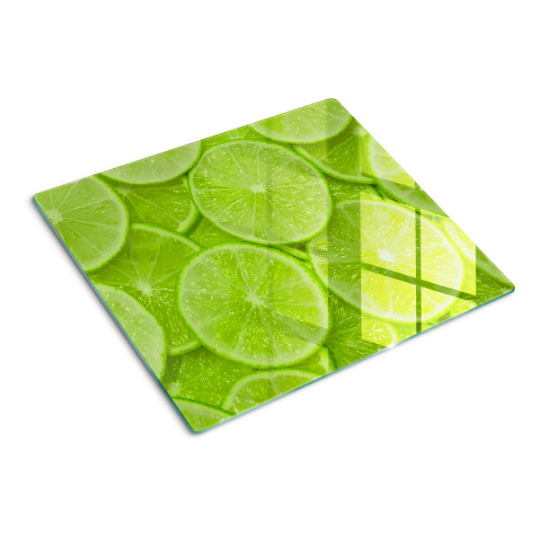 Tabla de cortar de cristal Rodajas de lima sobre un fondo verde