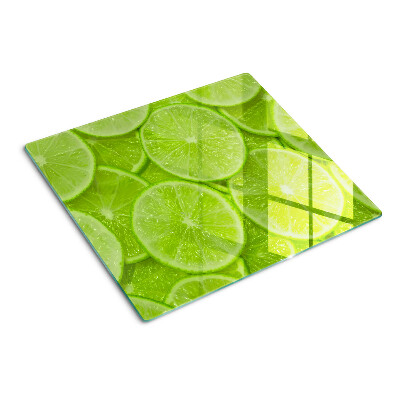 Tabla de cortar de cristal Rodajas de lima sobre un fondo verde