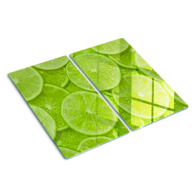 Tabla de cortar de cristal Rodajas de lima sobre un fondo verde