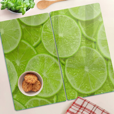 Tabla de cortar de cristal Rodajas de lima sobre un fondo verde