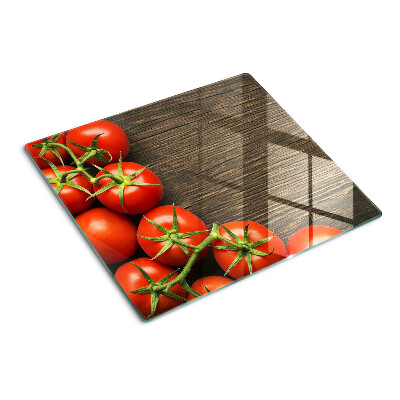 Tabla de cortar de cristal Tomates sobre un fondo de madera