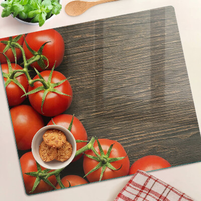 Tabla de cortar de cristal Tomates sobre un fondo de madera