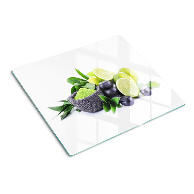 Tabla de cortar de cristal Limones y uvas sobre un fondo verde.