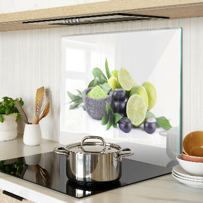Tabla de cortar de cristal Limones y uvas sobre un fondo verde.