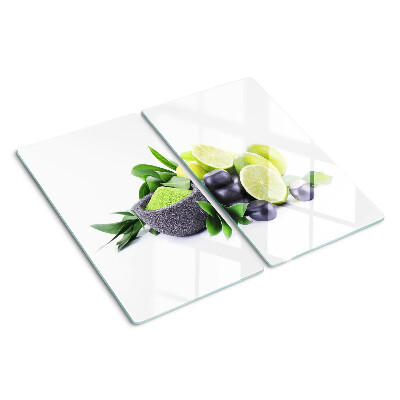 Tabla de cortar de cristal Limones y uvas sobre un fondo verde.