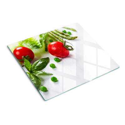 Tabla de cortar de cristal Verduras sobre una encimera blanca
