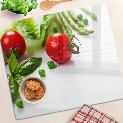 Tabla de cortar de cristal Verduras sobre una encimera blanca