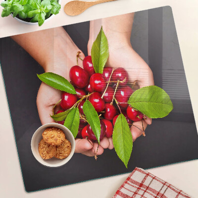 Tabla de cortar de cristal Cerezas rojas en las manos