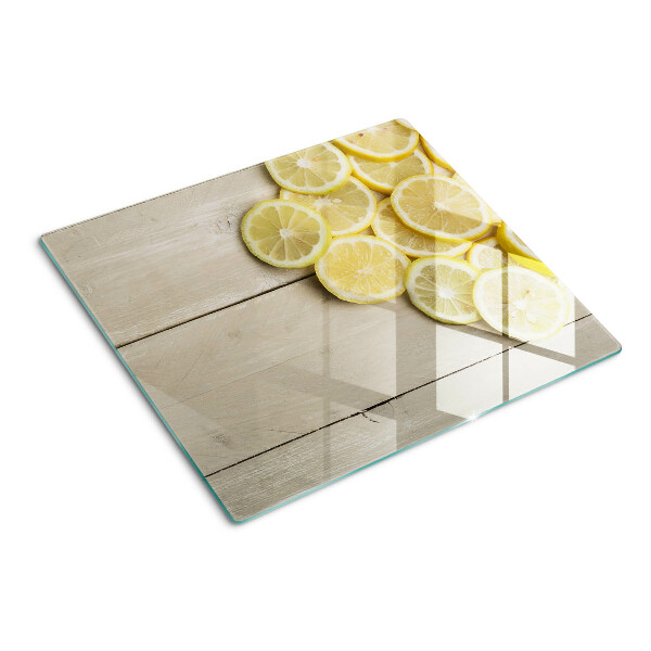 Tabla de cortar de cristal Rodajas de limón sobre un fondo de madera