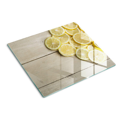 Tabla de cortar de cristal Rodajas de limón sobre un fondo de madera