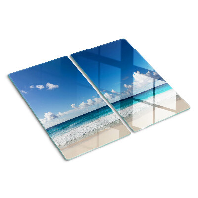 Tabla para cortar Playa con agua turquesa y nubes.