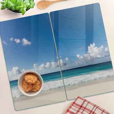 Tabla para cortar Playa con agua turquesa y nubes.