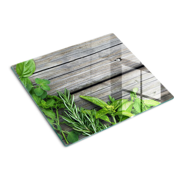 Tabla de cortar de cristal Hierbas verdes sobre fondo de madera