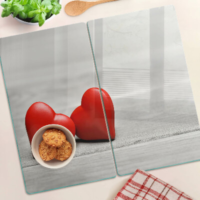 Tabla de cortar de cristal Corazones rojos sobre un fondo de madera
