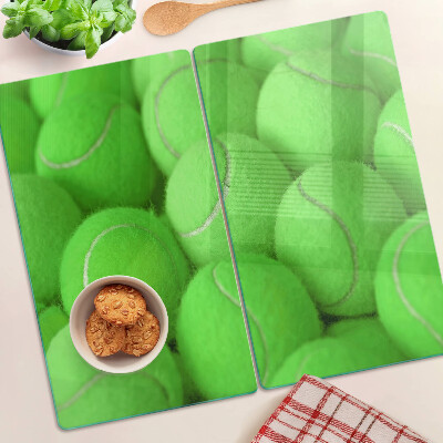Tabla de cortar de cristal Pelotas de tenis sobre un fondo verde