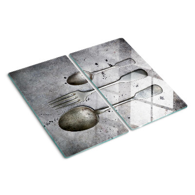 Tabla de cortar de cristal Cubiertos sobre un fondo de hormigón