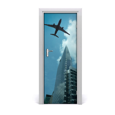 Pegatina para puerta Avión sobrevolando la ciudad